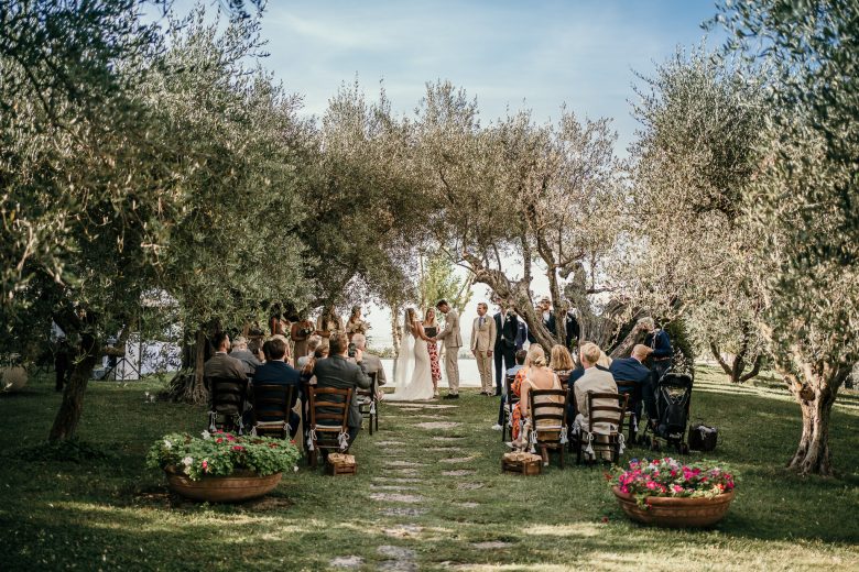 large view of a intimate wedding ceremony in Italy under some olive trees. Wedding photography by Ludovica & Valerio