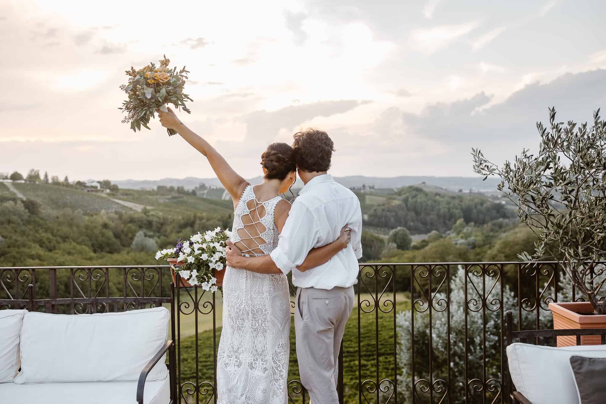 Bride and groom look to vineyards lanscape in Piedmont after their Italy elopement.