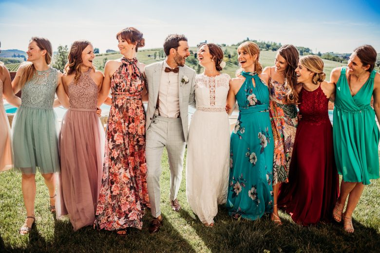Bride and groom laughing with bridesmaids in Italy, by Ludovica & Valerio, wedding photographers in Italy