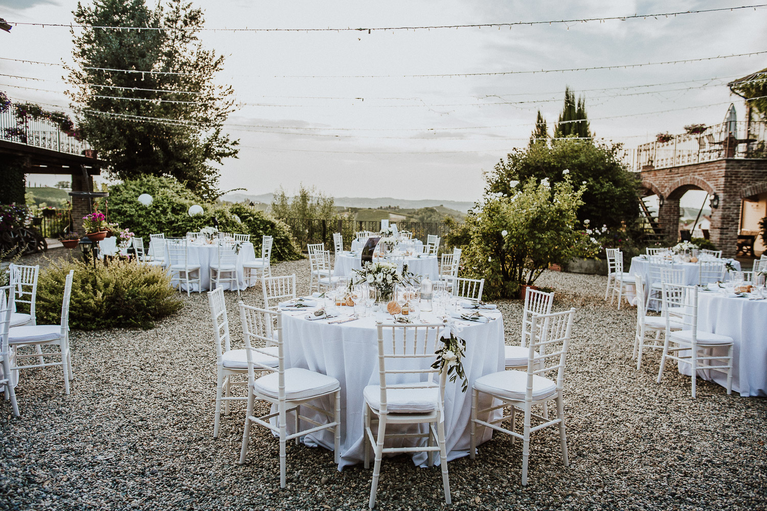 White round tables with white chiavarinas chairs at La Villa Hotel Mombaruzzo Italy